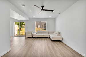 Living area with light wood-style flooring, a ceiling fan, a textured ceiling, and recessed lighting