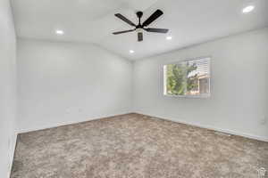 Carpeted spare room featuring lofted ceiling, recessed lighting, and a ceiling fan