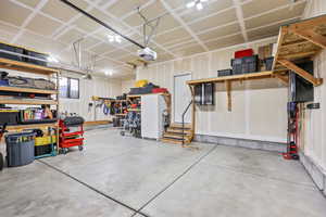 Garage featuring freestanding refrigerator and a garage door opener