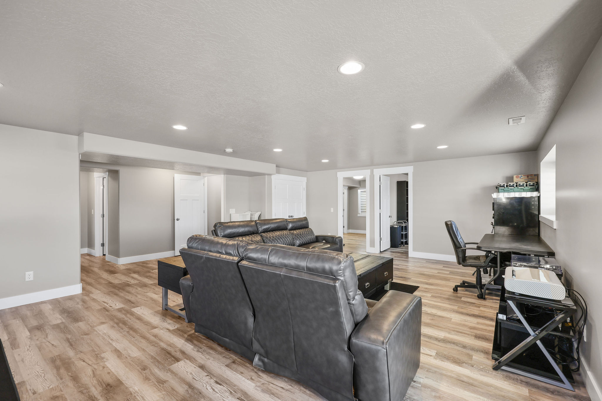 Living room featuring light wood-type flooring, recessed lighting, a textured ceiling, and a desk