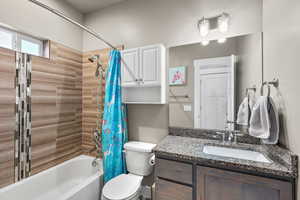 Bathroom featuring shower / tub combo with curtain and vanity