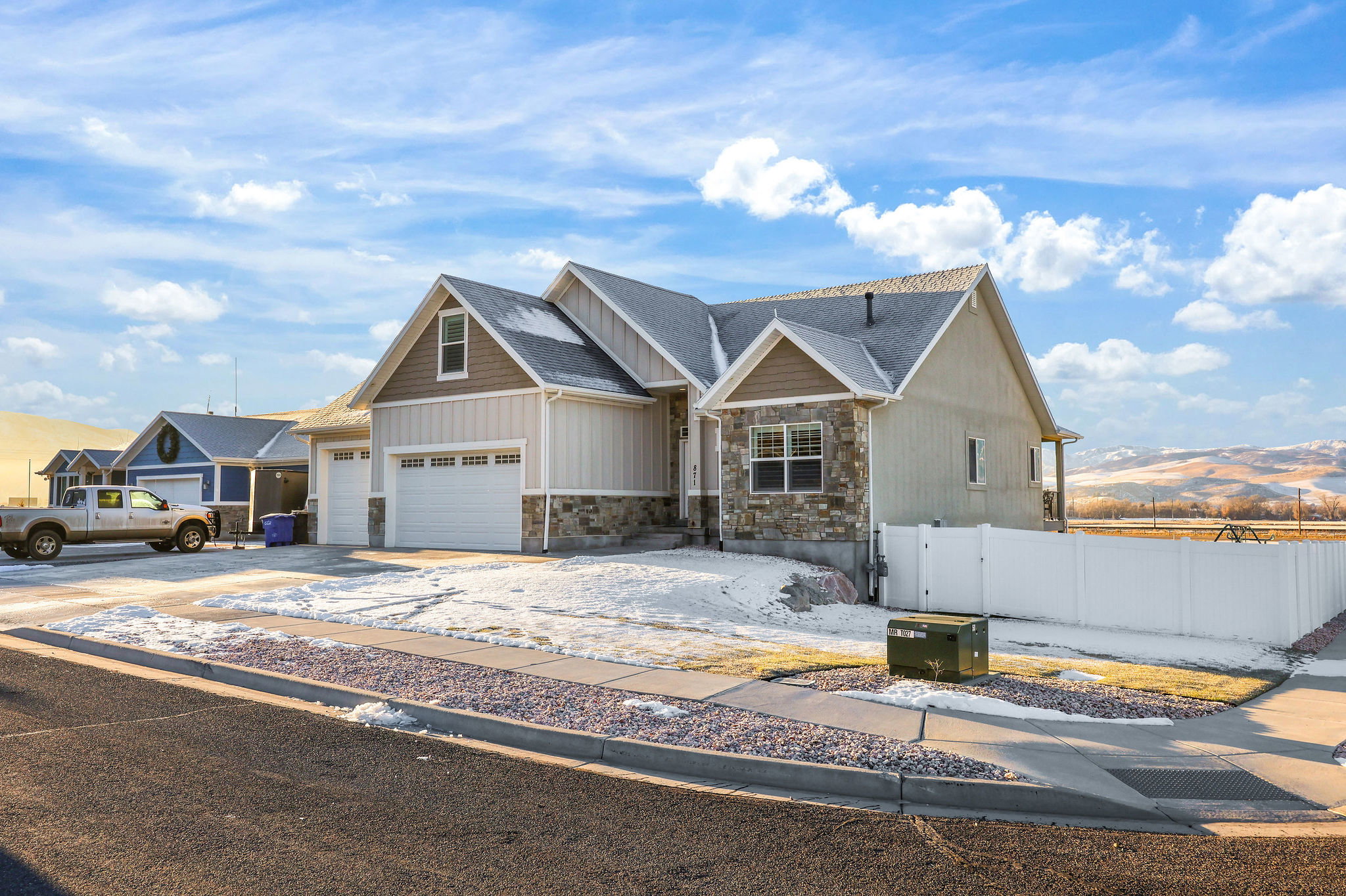 Craftsman-style house with stone siding, driveway, a mountain view, and a shingled roof