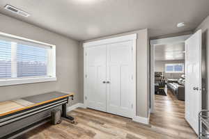 Interior space featuring a textured ceiling, light wood finished floors, and a closet