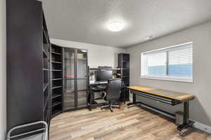 Office area featuring a textured ceiling and light wood finished floors