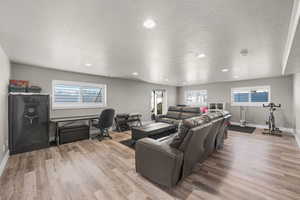 Living room featuring a desk, recessed lighting, a textured ceiling, and light wood-style floors