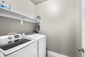 Washroom featuring baseboards and washer and dryer