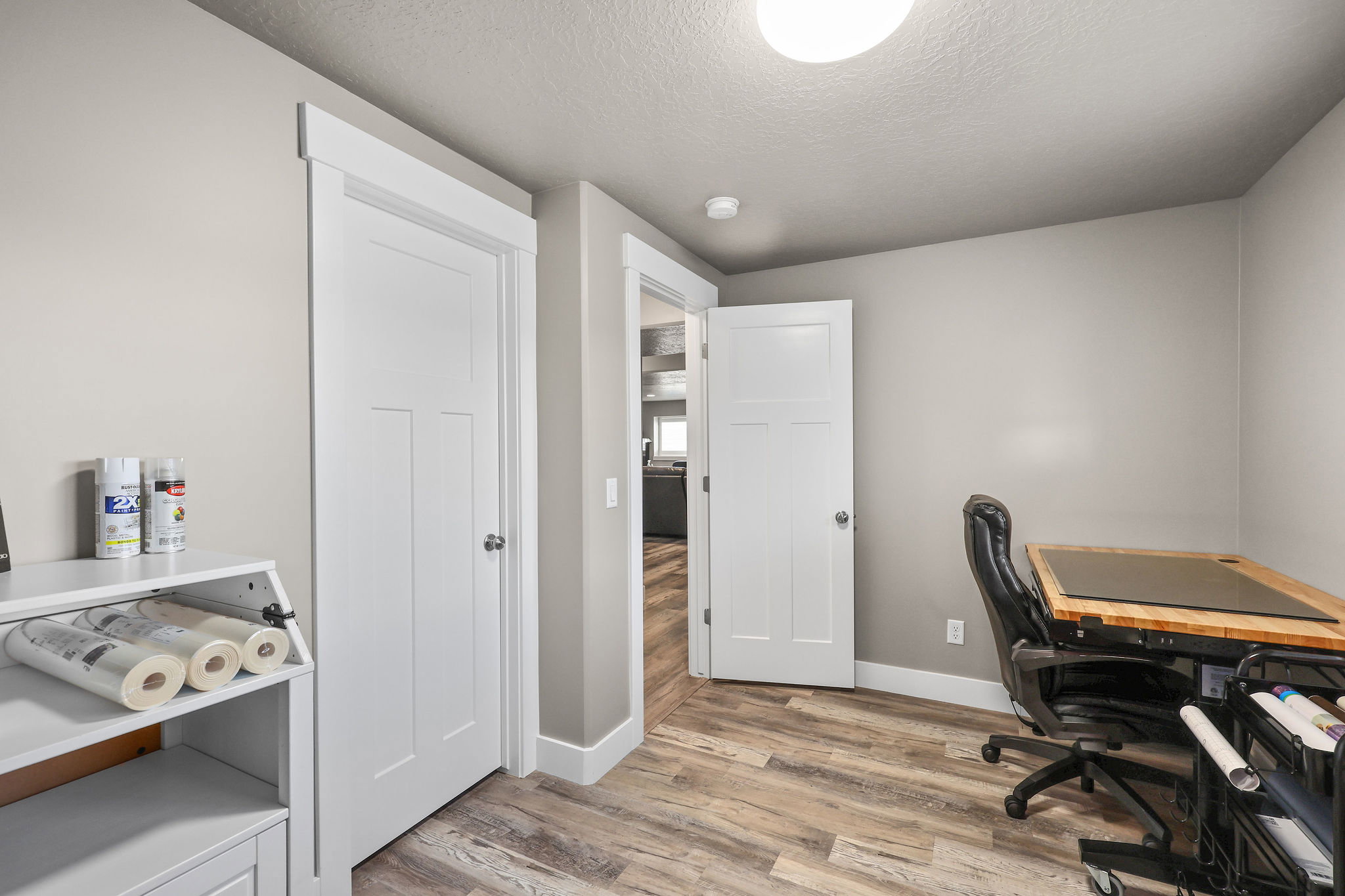 Office with light wood-style flooring and a textured ceiling