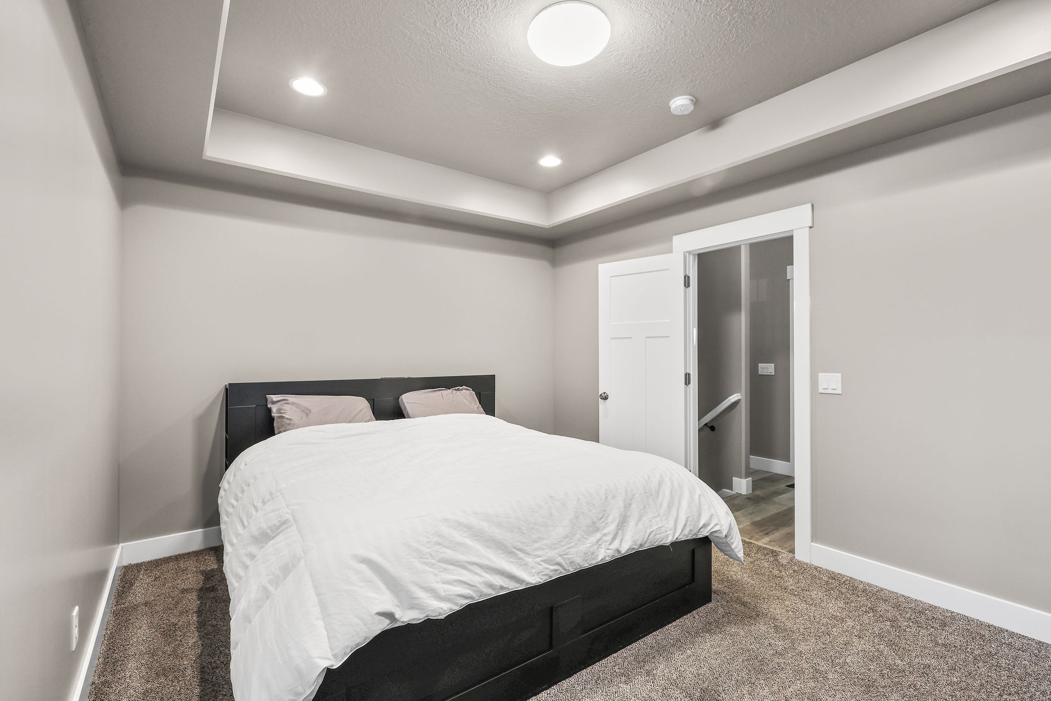 Bedroom with carpet floors, recessed lighting, a tray ceiling, and a textured ceiling