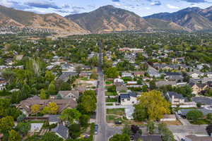 Aerial view of property and surrounding area with mountains and nearby suburban area