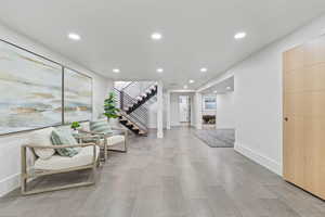 Living area featuring recessed lighting, stairway, and light wood-style floors