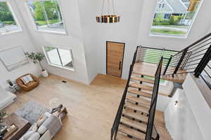 Stairs featuring a high ceiling, wood finished floors, and healthy amount of natural light