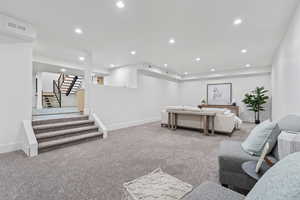 Living area with recessed lighting, carpet, and stairs