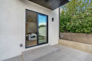 Property entrance with a patio area and stucco siding