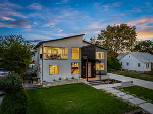 Contemporary home featuring stucco siding, a balcony, and driveway