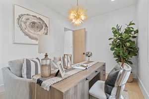 Office space with light wood-type flooring and a chandelier