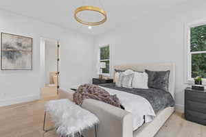 Bedroom featuring light wood-style floors, recessed lighting, and ensuite bath