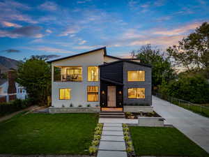 Modern home featuring concrete driveway, a balcony, and stucco siding