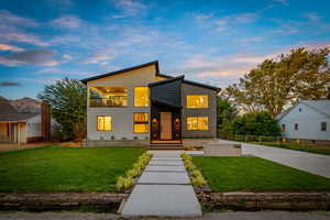 Contemporary home with a yard, a balcony, and stucco siding
