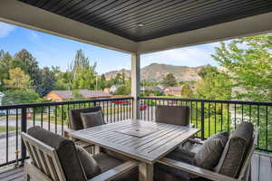 Wooden deck featuring a residential view, a mountain view, and outdoor dining space