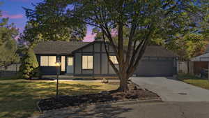 Tudor home with concrete driveway, roof with shingles, and an attached garage
