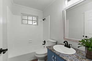 Full bathroom featuring vanity, shower / washtub combination, and ornamental molding