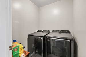 Laundry room featuring washing machine and clothes dryer and a textured ceiling