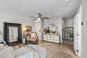Living area with light wood-style flooring and a ceiling fan