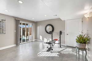 Workout area with finished concrete flooring, recessed lighting, and a textured ceiling