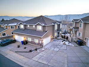 Traditional home with a mountain view, roof with shingles, a garage, and stucco siding