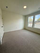 Unfurnished room featuring a textured ceiling and carpet flooring