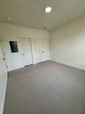 Unfurnished bedroom with carpet flooring and electric panel