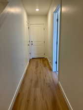 Hall with baseboards and light wood finished floors