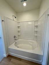 Full bathroom featuring wood finished floors and shower / bathtub combination