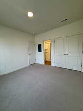 Unfurnished bedroom featuring carpet floors, a closet, and electric panel