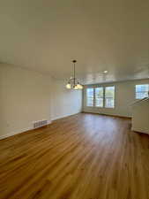 Unfurnished living room with a chandelier, light wood-style flooring, and recessed lighting