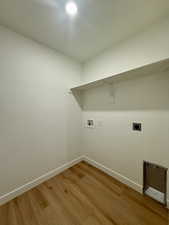 Laundry area featuring light wood-style flooring, hookup for a washing machine, and electric dryer hookup