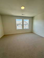 Empty room with carpet and a textured ceiling