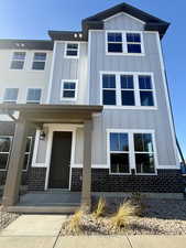 View of front of property with board and batten siding, a porch, and brick siding