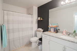 Bathroom with a shower with shower curtain, vanity, and light tile patterned floors