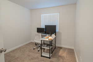 Home office featuring light colored carpet