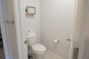 Bathroom with toilet and light tile patterned floors