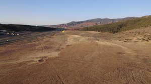 View of dirt / gravel road with a mountain view and a view of rural / pastoral area