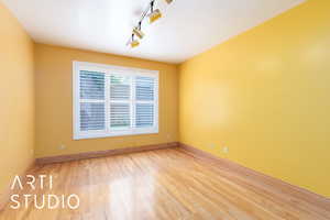 Spare room featuring track lighting and light wood finished floors