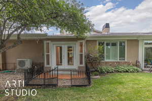 Property entrance with a patio area, stucco siding, french doors, and a chimney