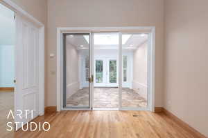 Doorway to outside with wood finished floors and french doors