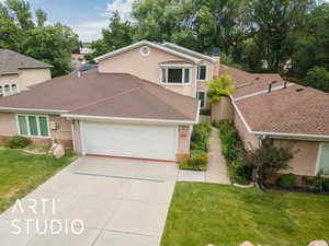 Traditional-style house featuring an attached garage, stucco siding, concrete driveway, and a front yard