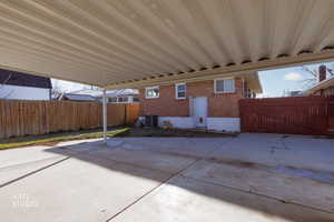 Fenced backyard with a patio and an attached carport