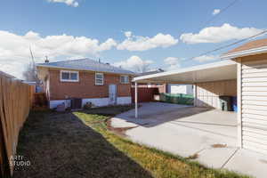 Back of house featuring brick siding, a patio, concrete driveway, and roof with shingles