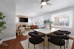 Dining area with a fireplace, dark wood-style flooring, and healthy amount of natural light