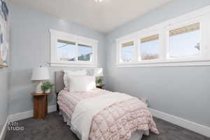 Bedroom with baseboards and dark carpet